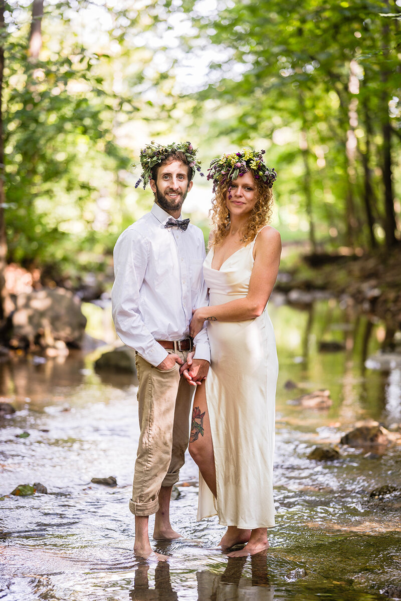 A couple on their elopement day hold hands and pose together for a formal portrait on their elopement day at Fishburn Park in Roanoke, Virginia.