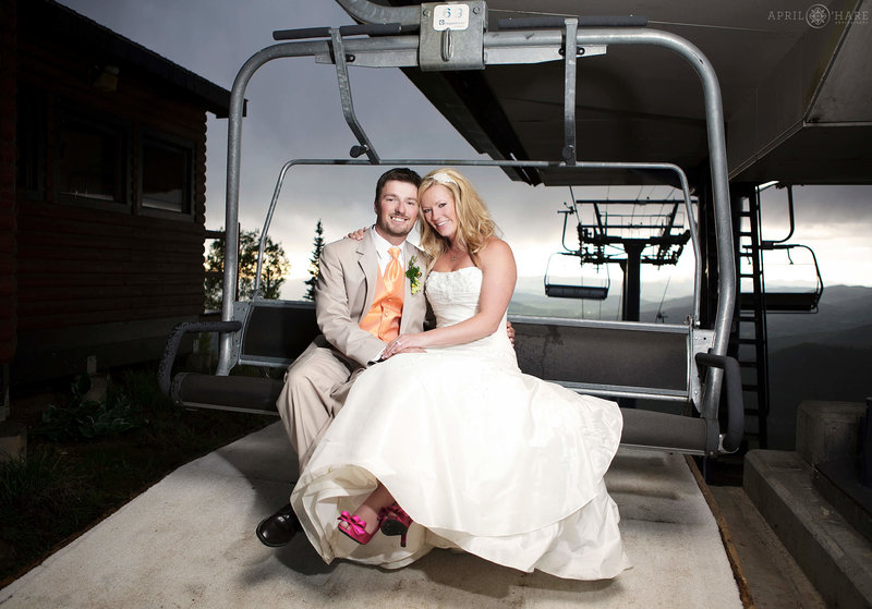 Couple poses for a photo on a ski lift at Steamboat Springs Ski Resort at their summer wedding in Colorado
