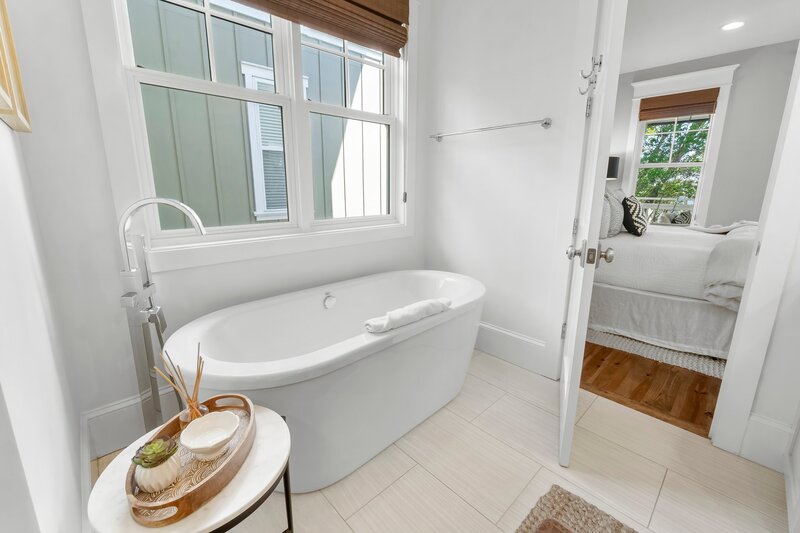 Soaking tub with natural light and modern fixtures in a serene bathroom at Tangerine Dream vacation rental.
