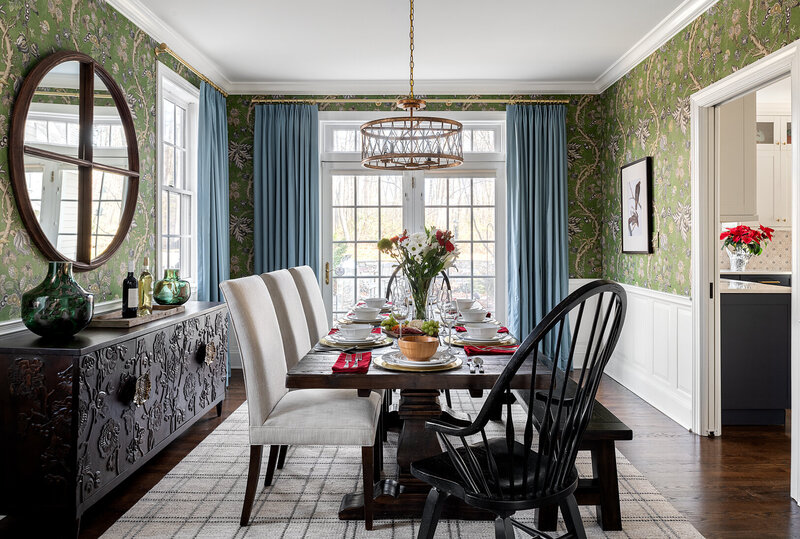 dark moody dining room with dark wood table and white chairs