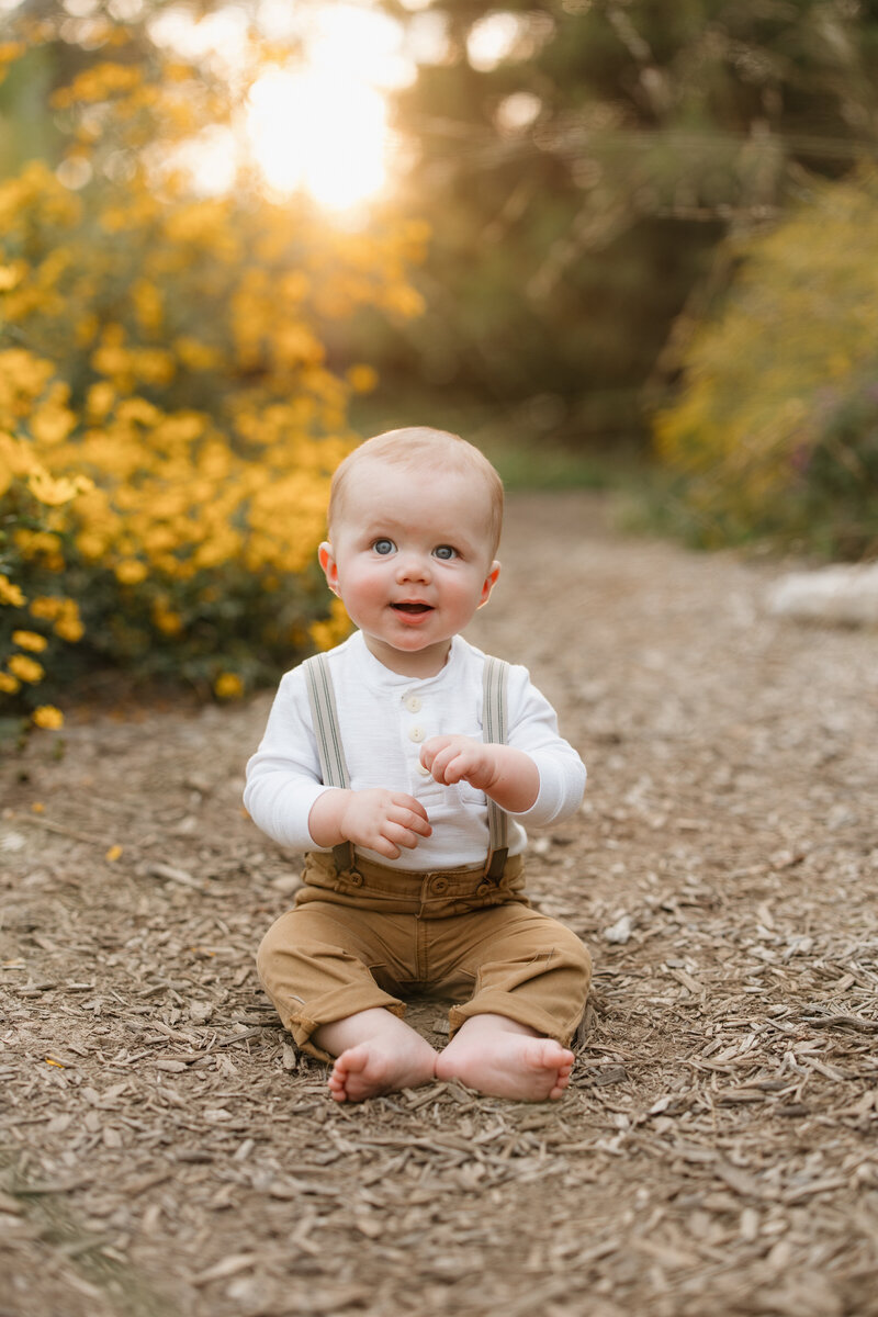 Infant boy looking at camera while wearing suspenders