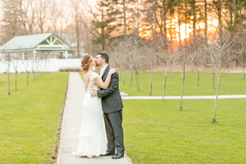 Bride and groom kissing at sunset