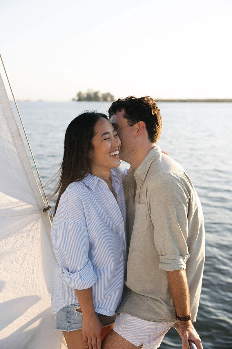 Coleen & Casey stands on a boat, smiling and enjoying a sunny day on the water.