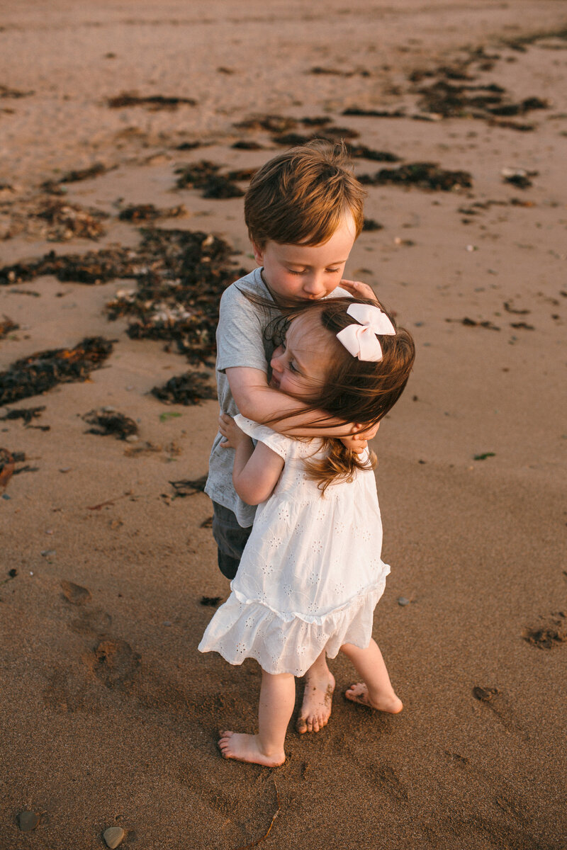 Siblings embrace at the beach in south devon