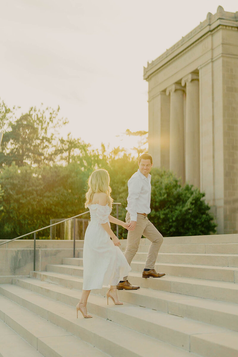 Couple holding hands at sunset engagement photoshoot in Nelson Atkins Museum