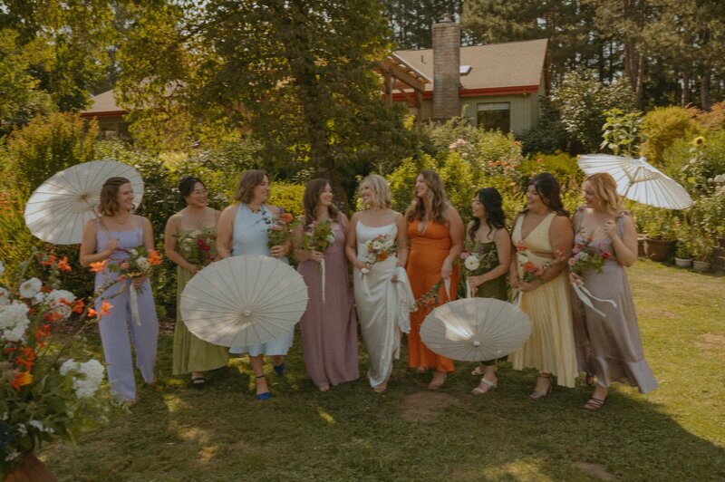 Mismatched bridesmaids dresses with paper umbrellas