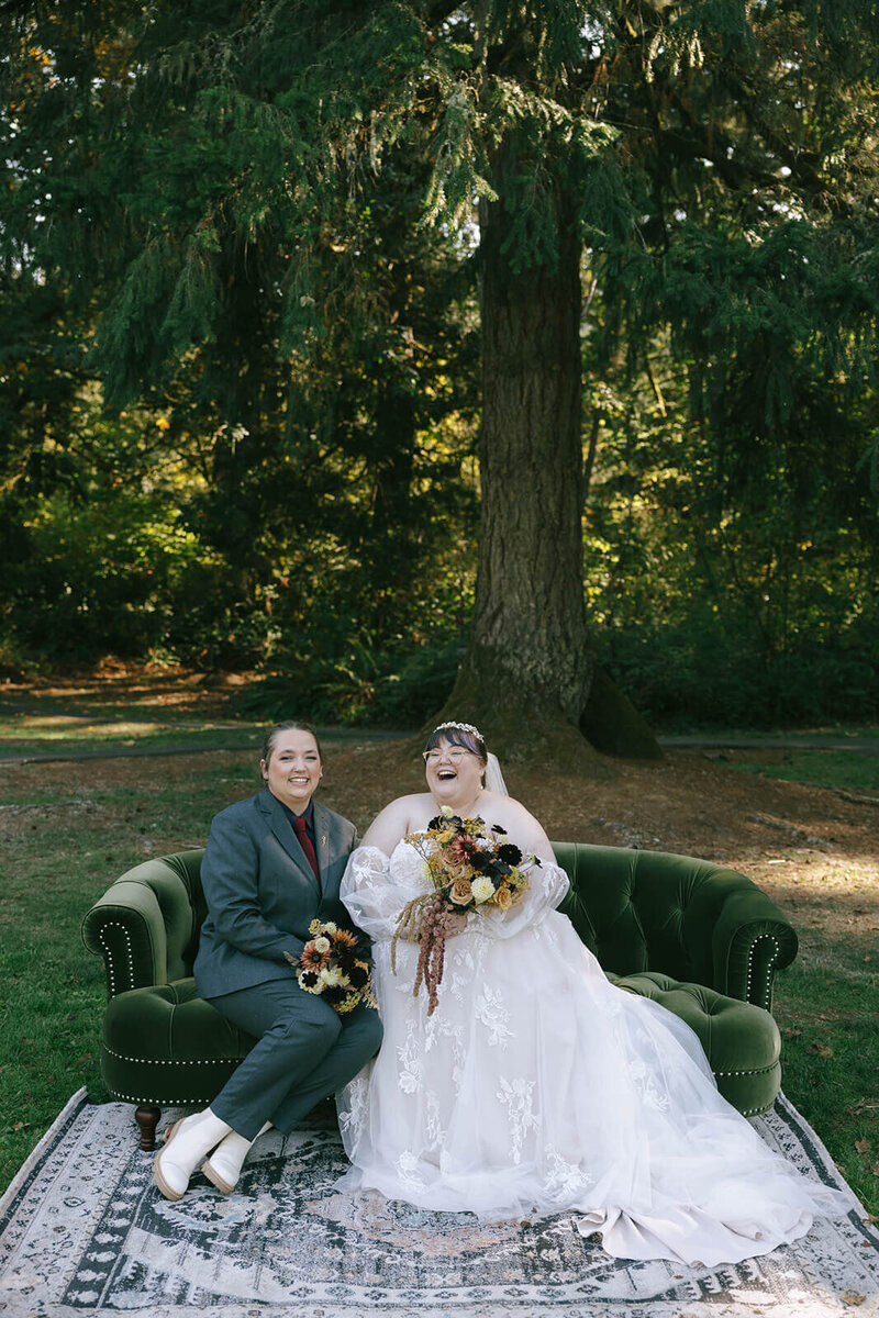 A bride and guest on a rental sofa at an outdoor wedding, representing event coordinator services and Eugene wedding planners Birdie June. 