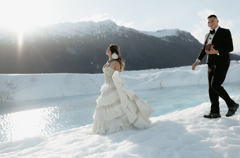 A man walking towards a woman while standing on a glacier.