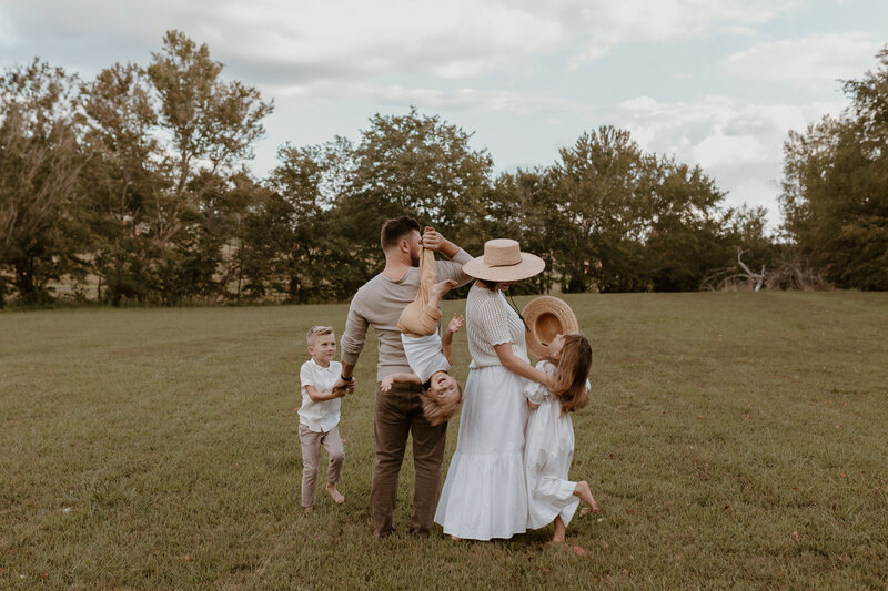 outdoor family photography session located in columbia, tennessee of a candid shot with their little boy hanging upside down