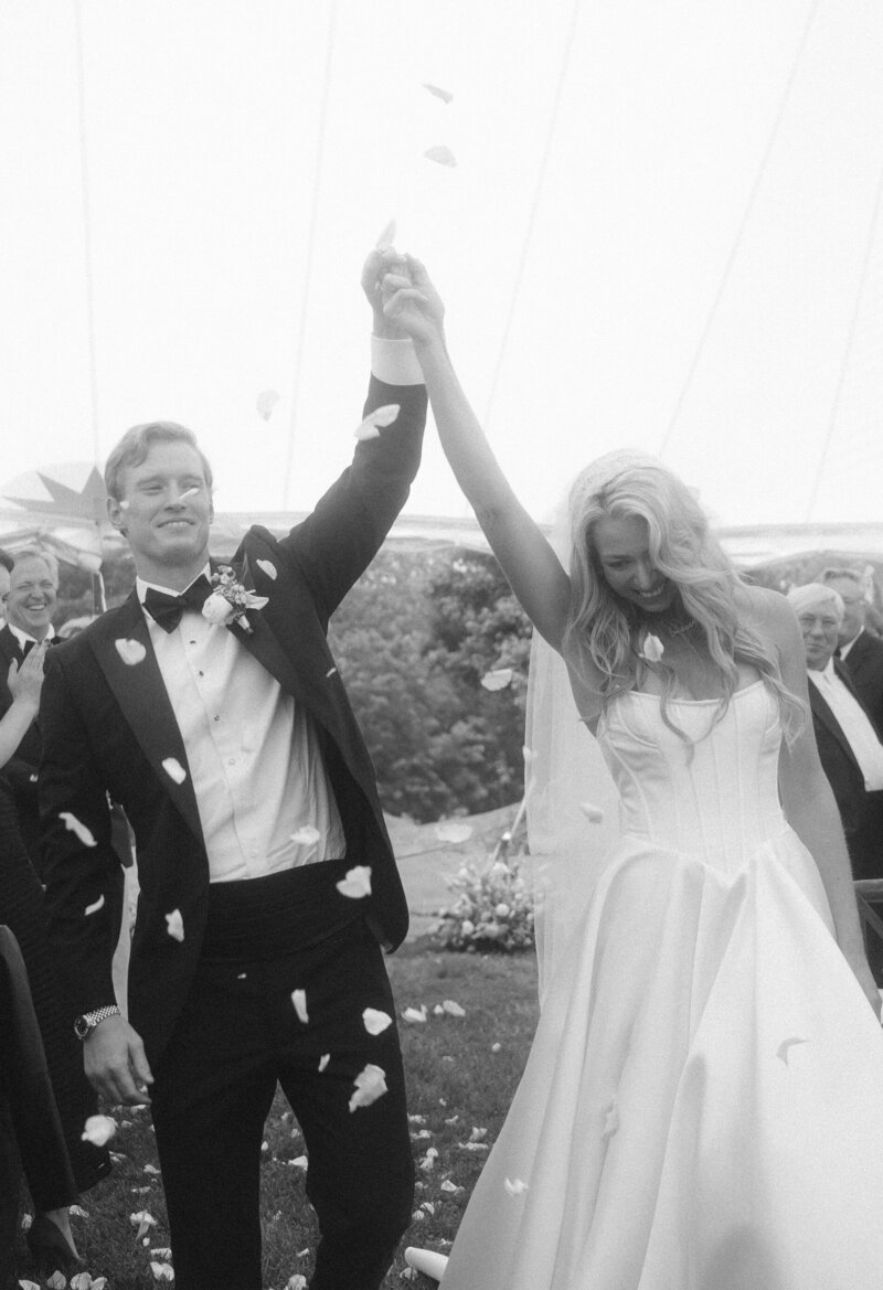 bride and groom walk hand in hand in front of their branford house wedding venue photo by cait fletcher photography