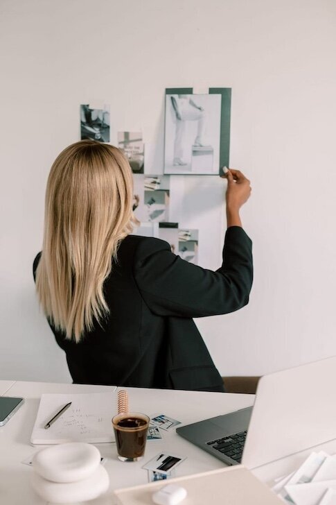 designer hangs images on wall