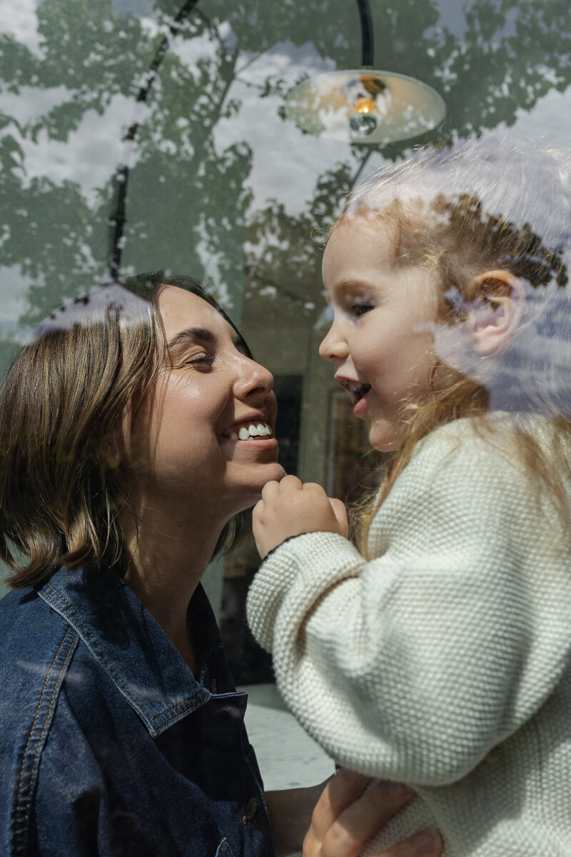 Mother smiling up close to her daughter's face.