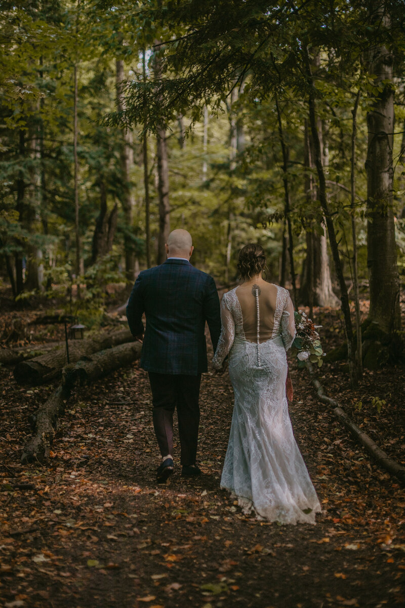 bride and groom walking in forest at the  Ashwood Inn Bayfield