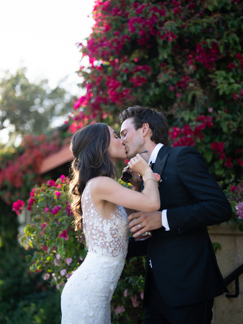 Back of woman's wedding dress holding white flowers