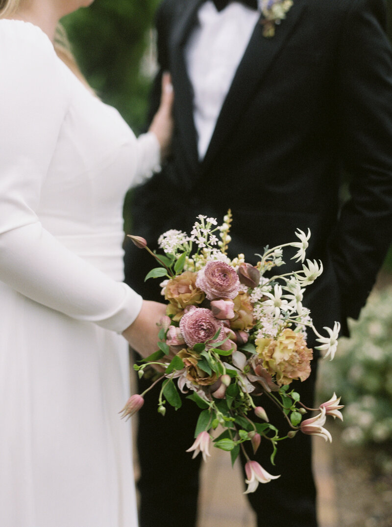 groom in tuxedo tying shoes