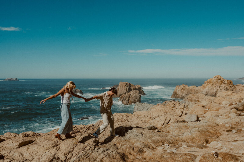 couple walking together along the rocky shores of Big Sur, CA