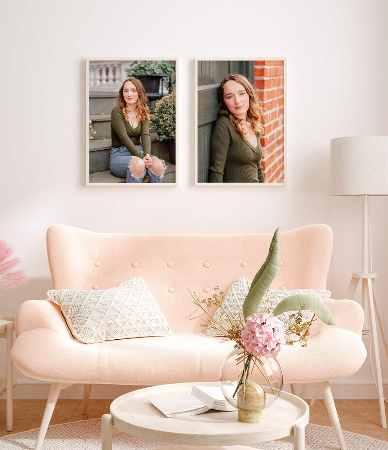 A high school senior, wearing jeans and a green top, sits on some stone steps. The other picture has the same senior leaning against an old door in a brick wall. The portraits are hung over a light pink couch with white pillows.