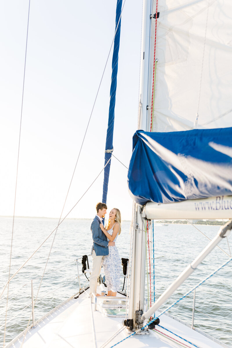 bride and groom laughing on sailboat in charleston harbor
