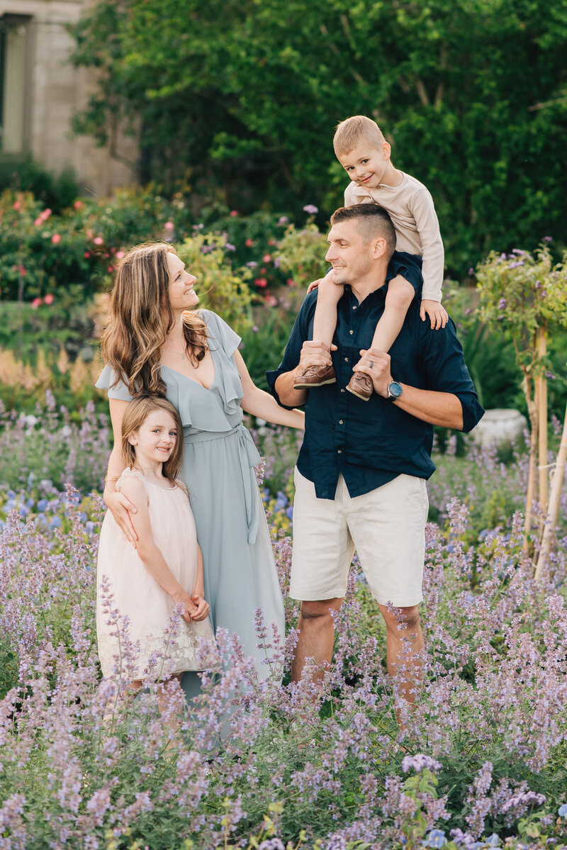 Couple in field, looking down at pregnant mom's belly
