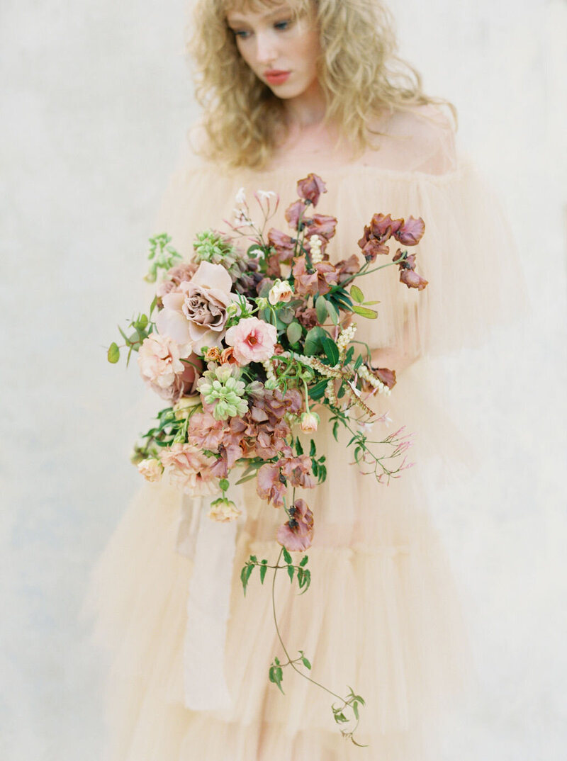 blonde girl in peach dress with mauve and green wild bouquet