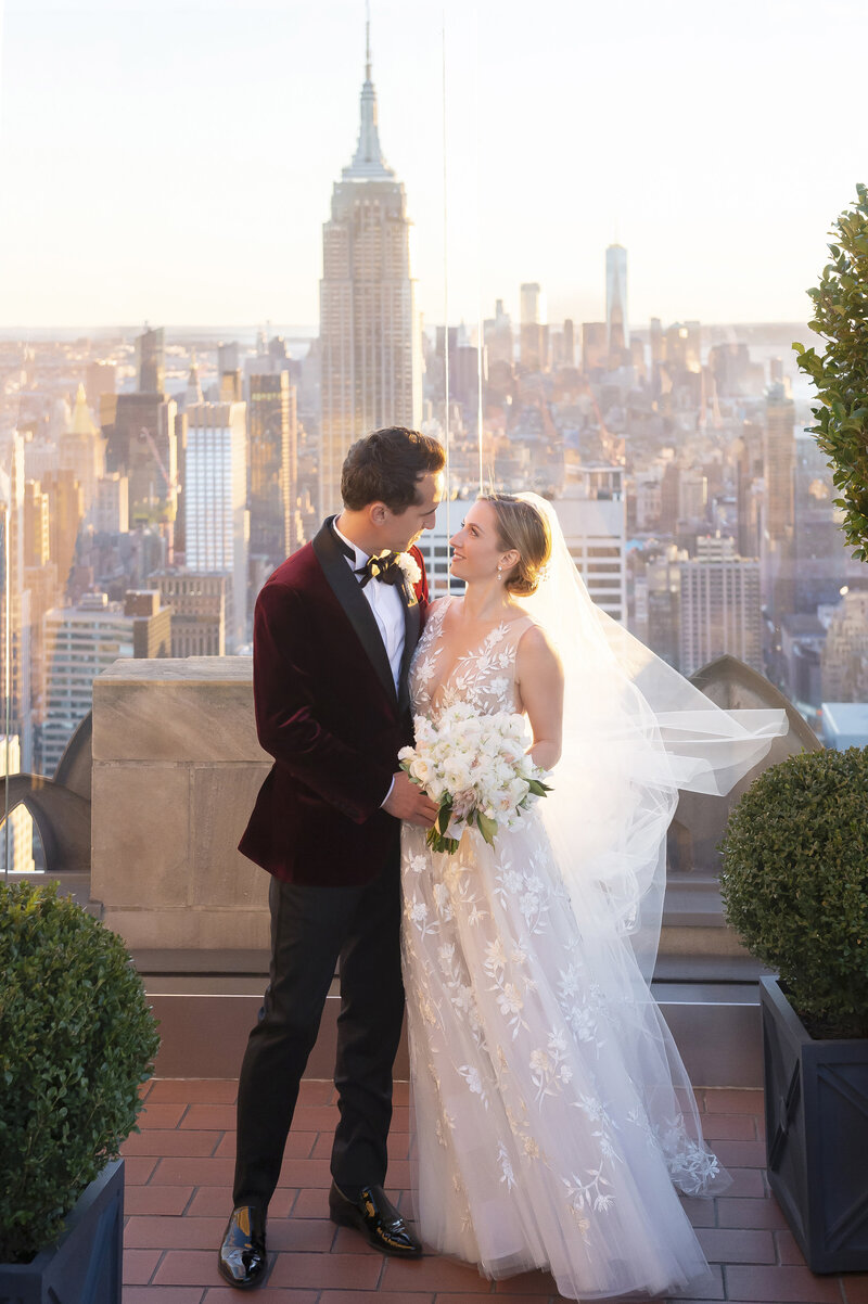 Bride and groom looking at each other in front of NYC skyline