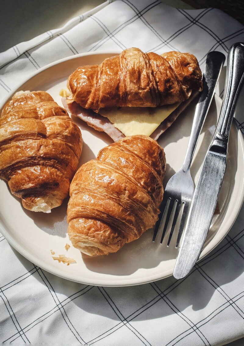 Three croissants with silverware on a plate
