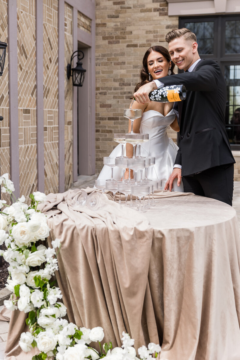 Bride and groom pouring champagne at wedding reception