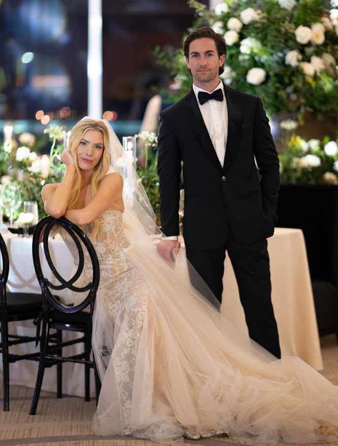 Bride in white lace dress long sleeve embracing groom in black tux