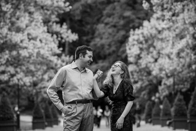Couple laughing together at Longwood Gardens, sharing a candid and joyful moment during their engagement session.