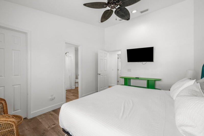 Spacious king suite with private bath and mounted TV, perfect for couples or small families booking PCB or 30A vacation homes.