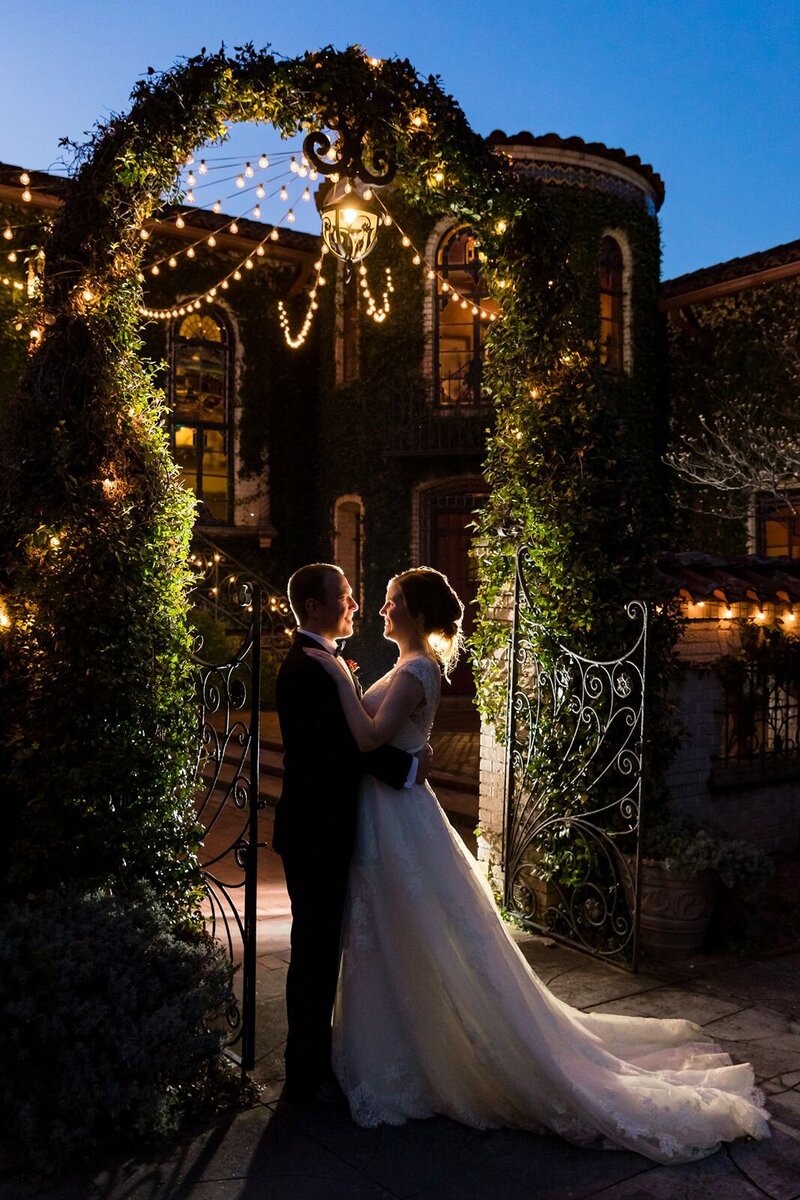 backlit bride and groom embrace