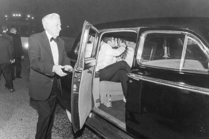 Couple leaving wedding in vintage car at night, documented by a Seattle-based Destination Wedding Photographer specializing in timeless elegance.