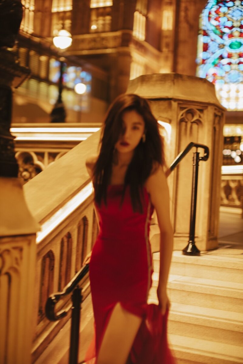 Destination couture photoshoot with a woman in. a red gown at night in the city.
