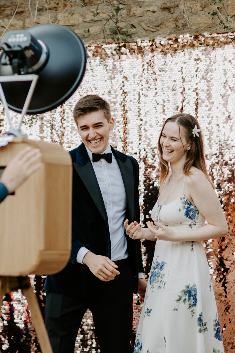2 guests posing against a champagne sequins backdrop, for a luxury photo booth rental experience in Chipping Campden, cotswolds