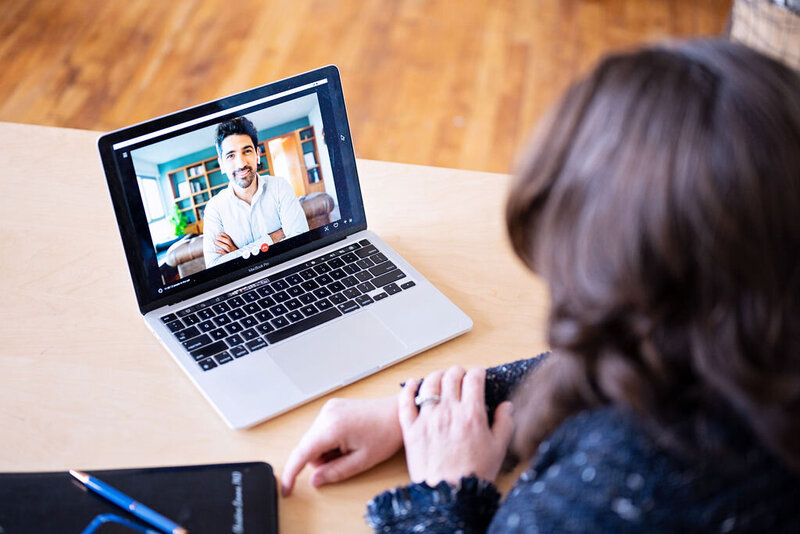 Chris meeting virtually with a client on her laptop, engaged in a one-on-one video call.