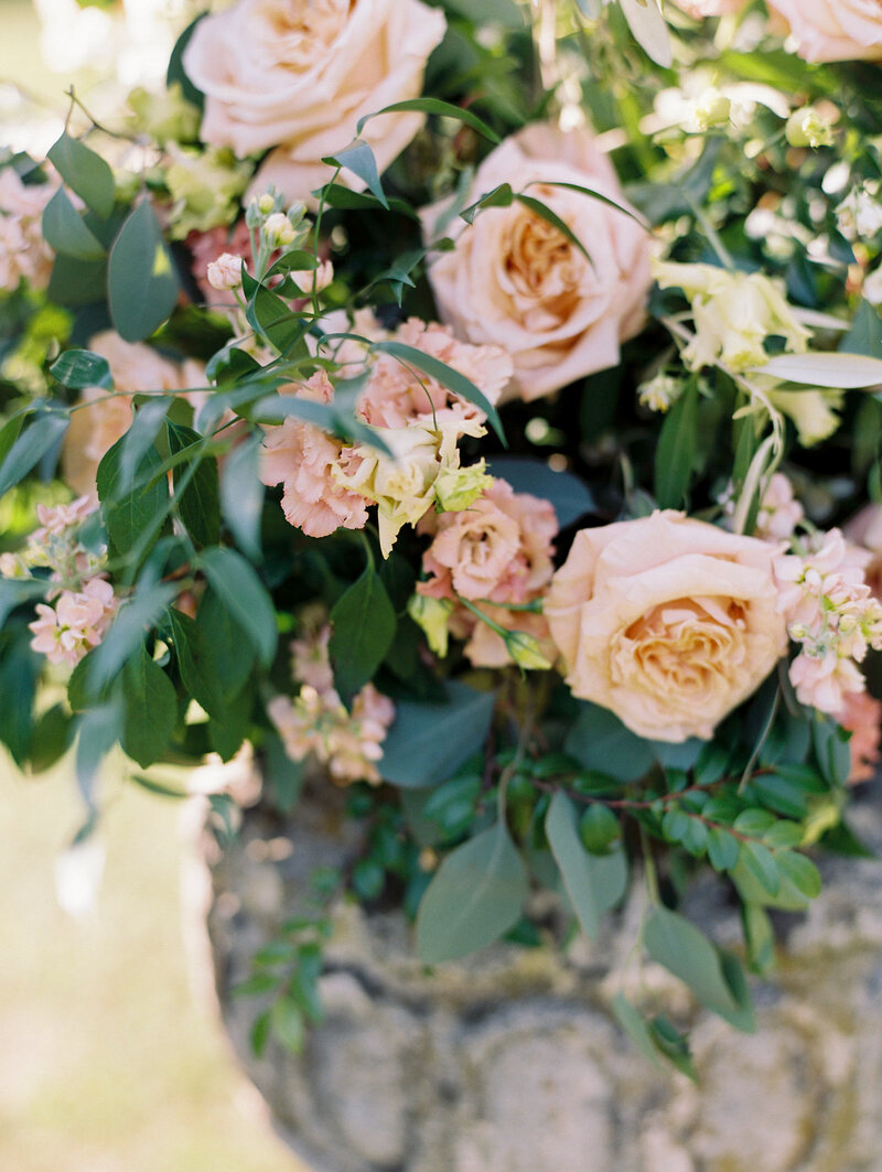 Pink, Orange, and Peach wedding floral arrangement in urn