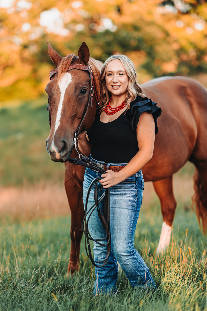 High school senior posing with her horse in rural Wisconsin
