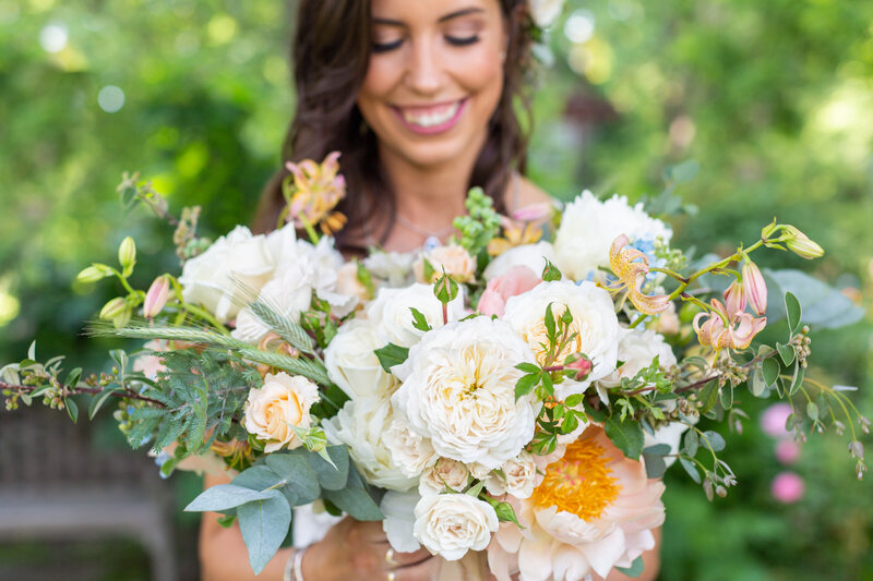 bride smiling holding fresh floral bouquet