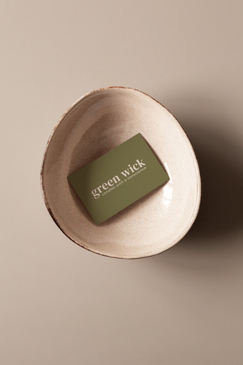 green business card for candle brand inside a bowl