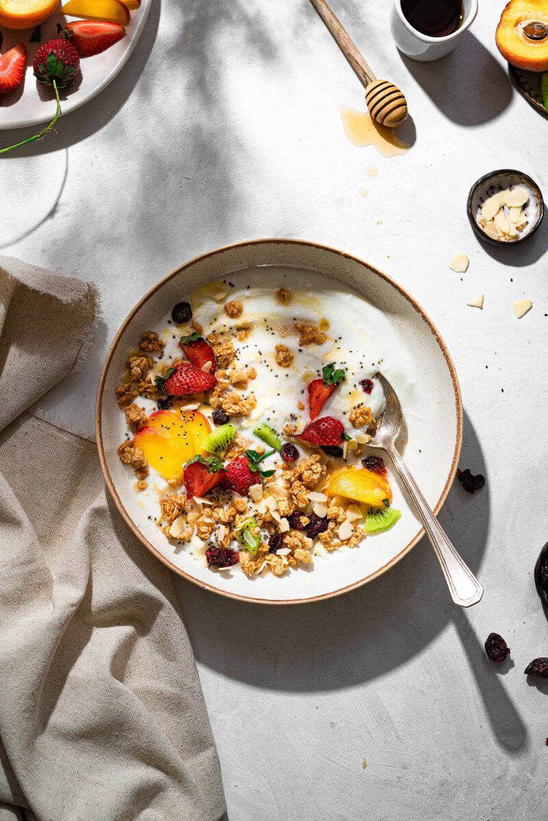 A bowl of museli with refreshing fruits and nuts on top