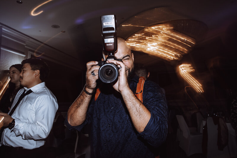 A BTS photo of Joe Catoe, second shooter, photographing during a wedding.