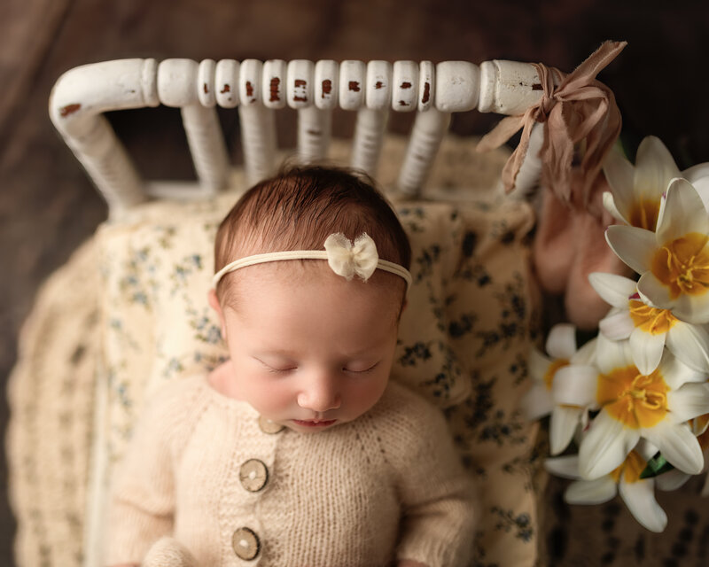 Newborn photographed on a rustic vintage spindle bed with daffodils in Paris, Ontario. A spring-inspired heirloom portrait.