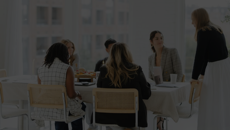 Woman gathered around a table in a naturally bright room to network and discuss the creative industry in Chicago and across the globe.