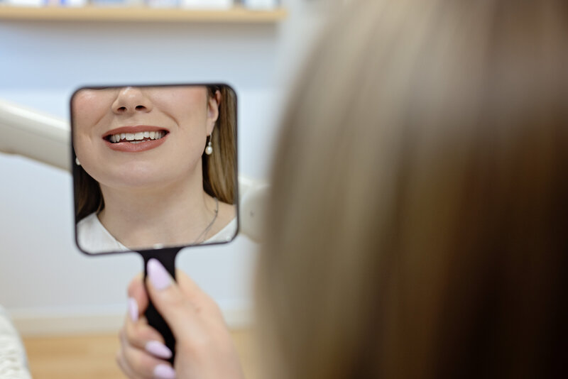 patient looking at teeth in mirror