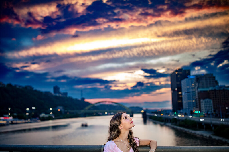 Dramatic bright colored senior girl in Pittsburgh pa iconic bridge at night with artistic composition. 