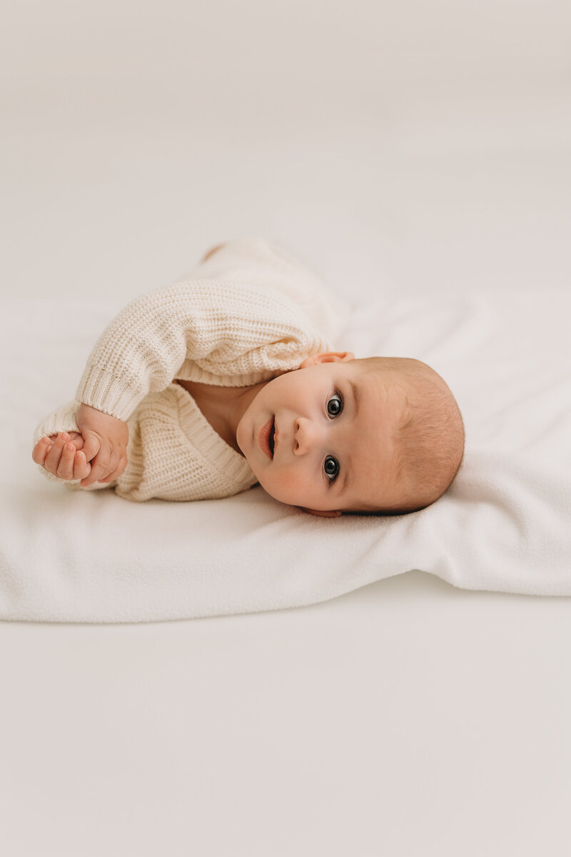 Baby lying down looking at camera