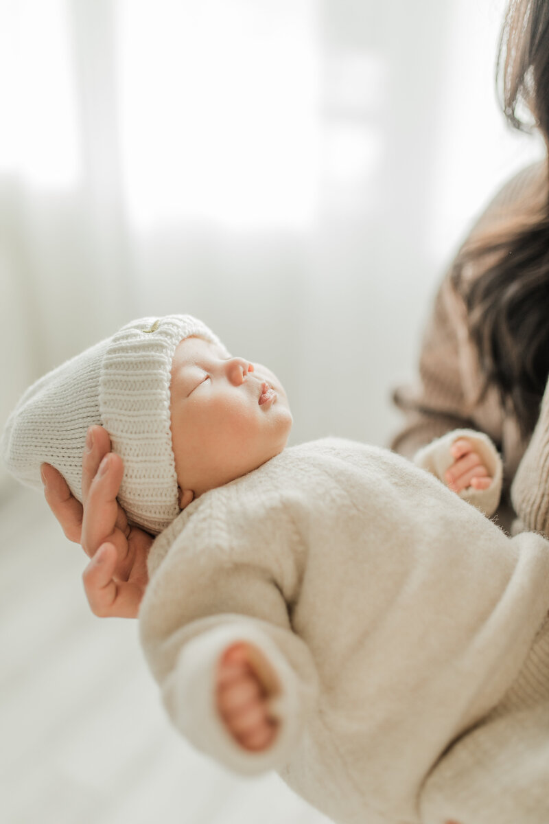 Close up of a toddler held by the mother