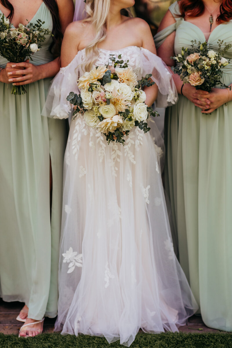 bride holding flower bouquet with bridesmaids