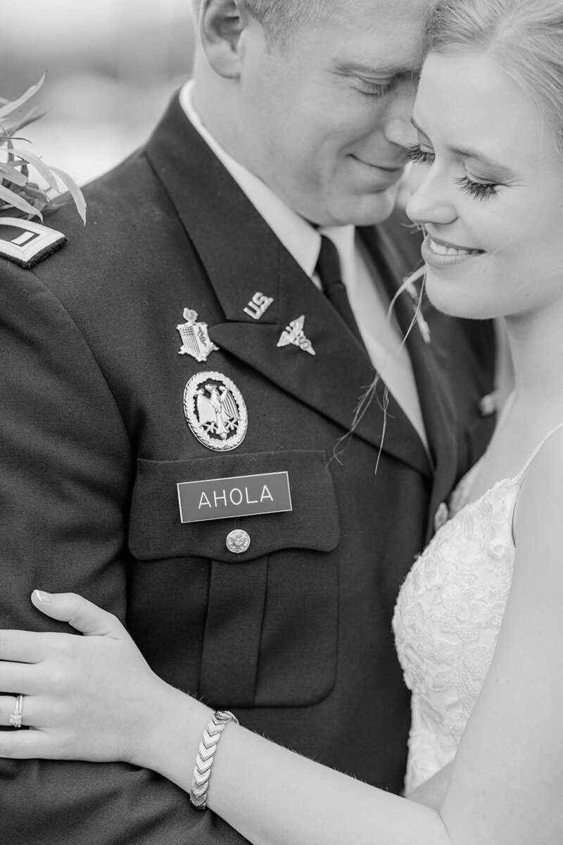 groom in uniform embracing his bride