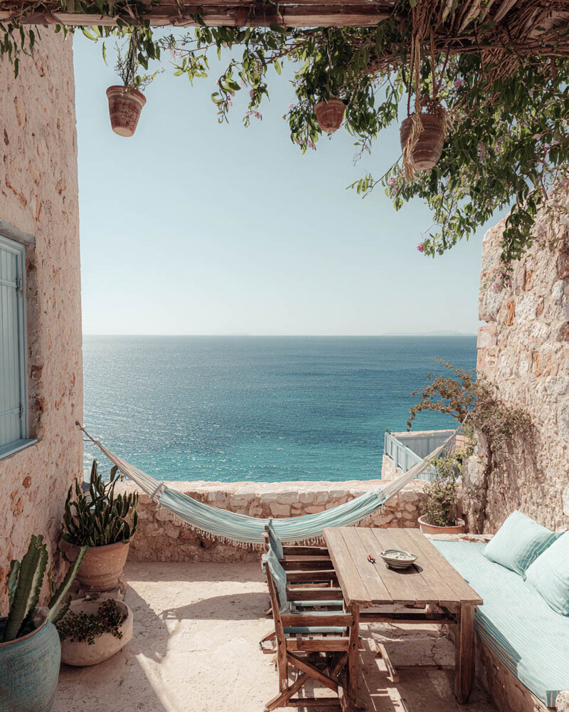 Coastal view from a Tuscan-inspired verandah, capturing the ocean horizon. Tailored Oasis Travel Co.